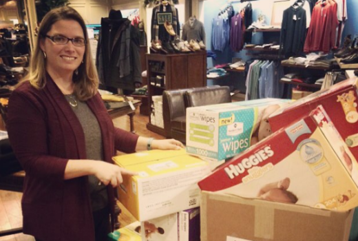 woman smiling and standing next to boxes