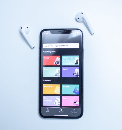 Spotify app on a mobile phone with earbuds
