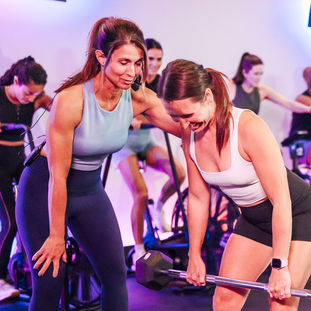 Coach helping client curl weights