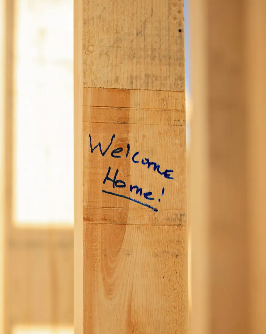 Welcome home written on an unfinished Beam