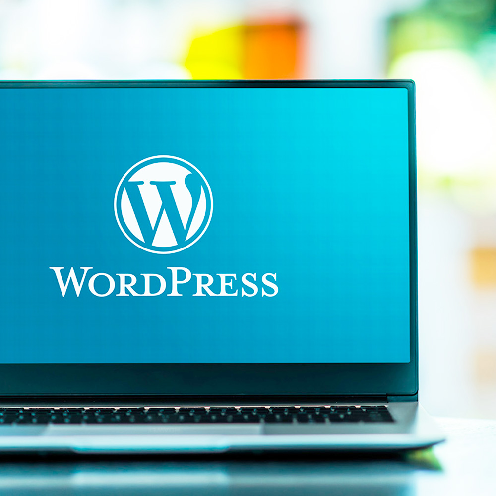 Laptop sitting on table with WordPress logo