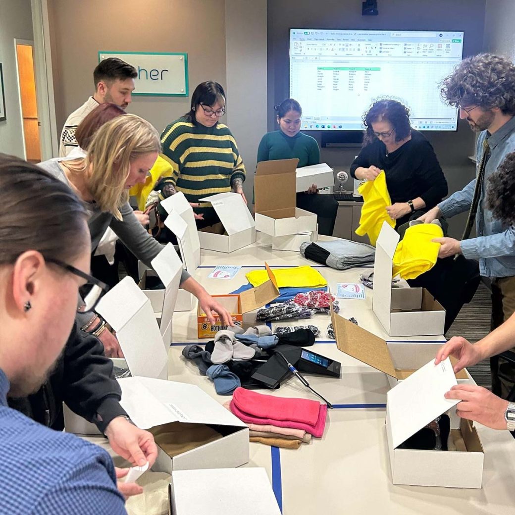 Asher team members in a conference room assembling cold-weather kits for United Way of Allen County