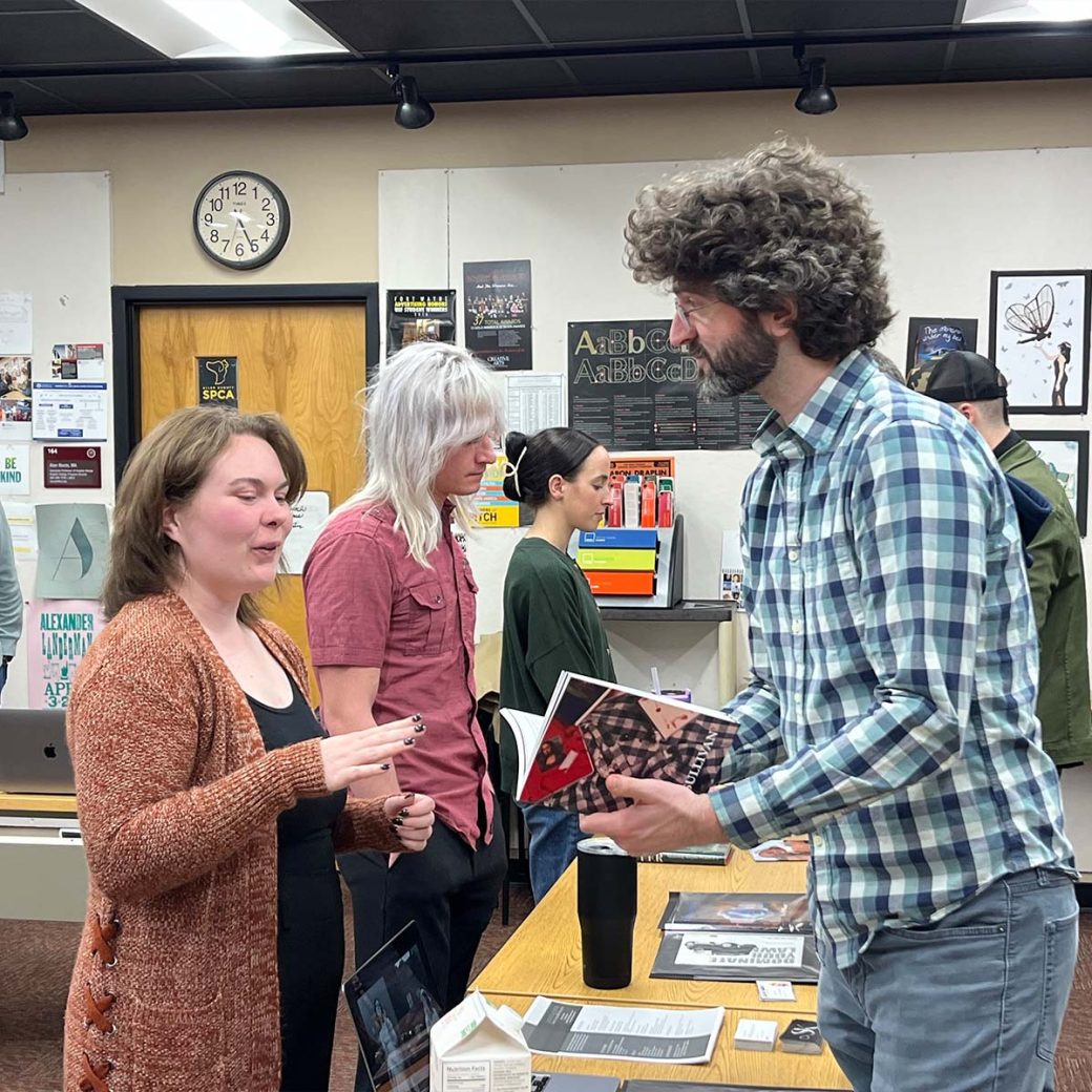 Brandon Peat, Asher Director of Web Development, talks with a student about their portfolio.