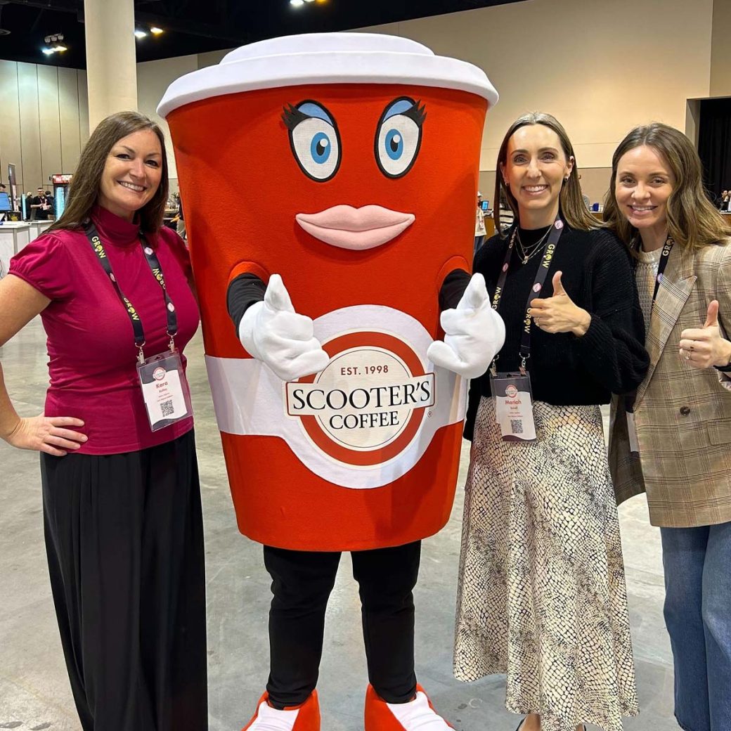 Kara Kelley, Mariah Schall and Ashley Miller standing with the Scooter's Coffee mascot
