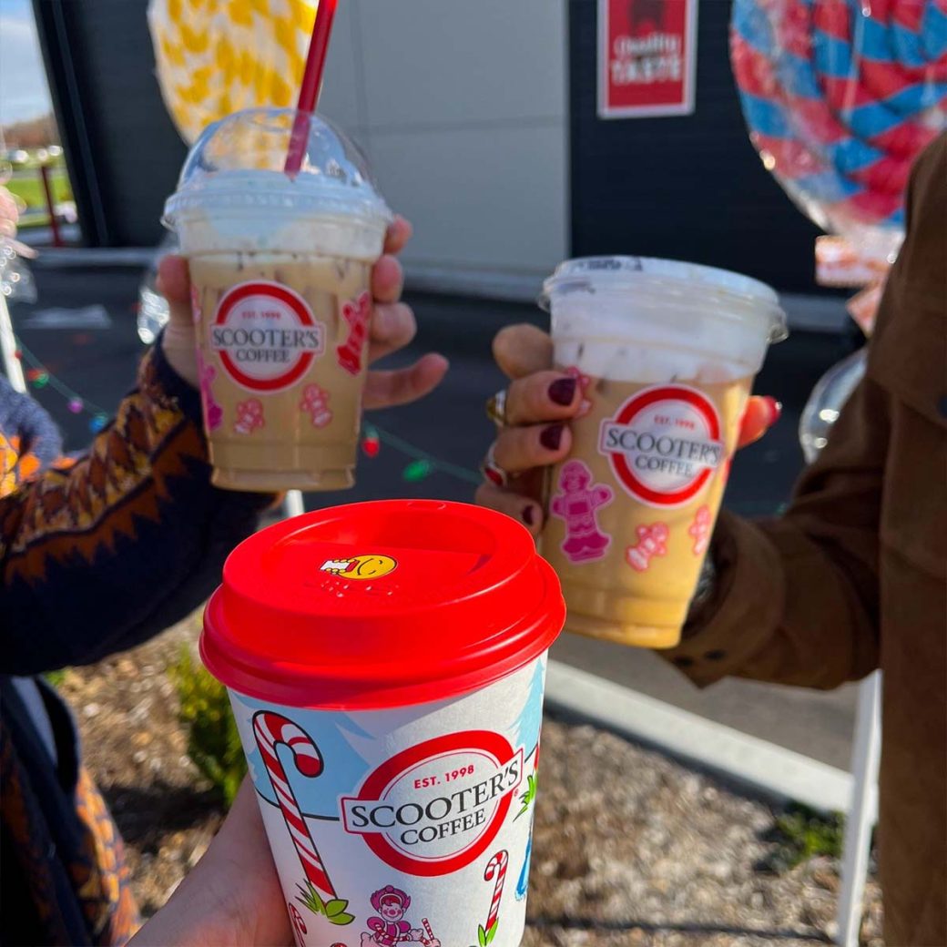 Asher team members cheers with Scooter's Coffee cups.