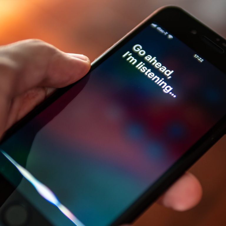 Siri, Apple's voice-activated digital assistant, tells iPhone user to ask her by showing the text "Go ahead, I'm listening" on the display.