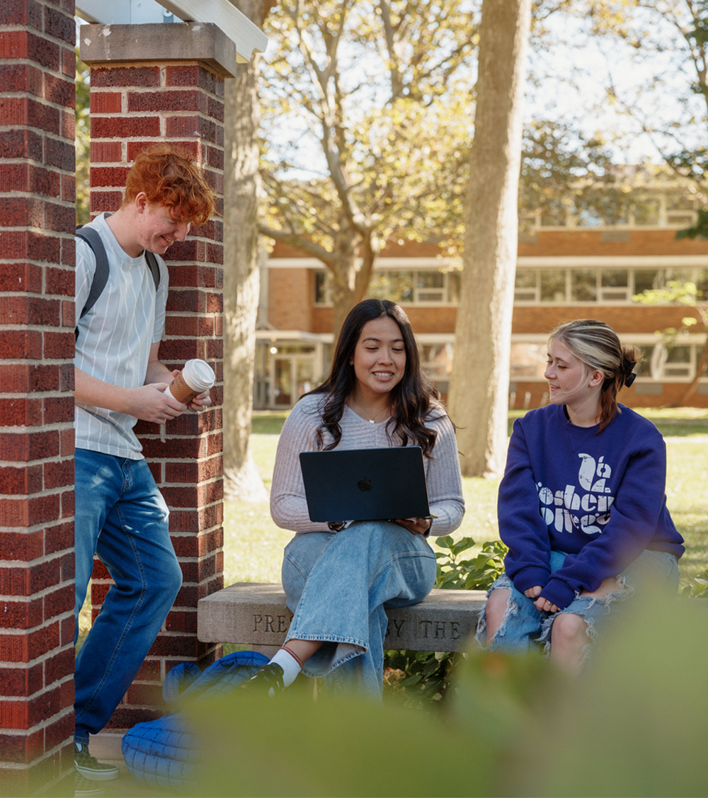 three college students smiling and talking