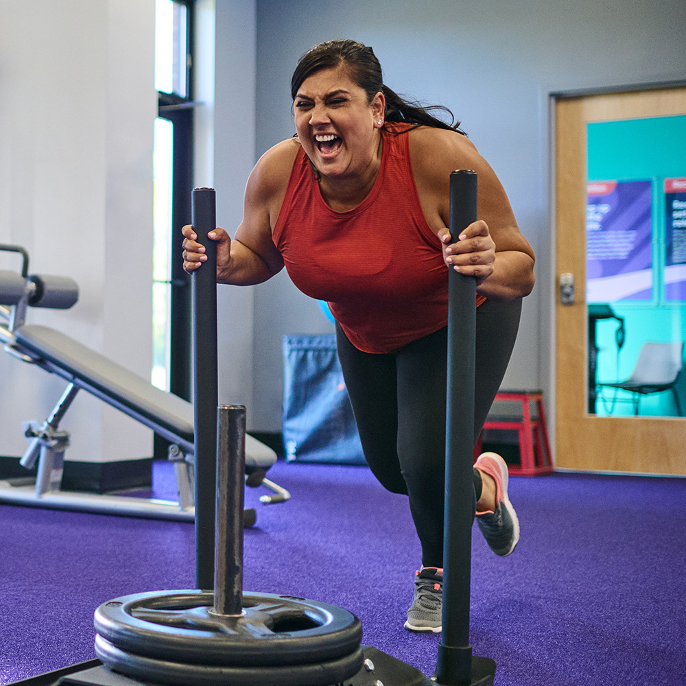 Woman in workout gear pushing weights