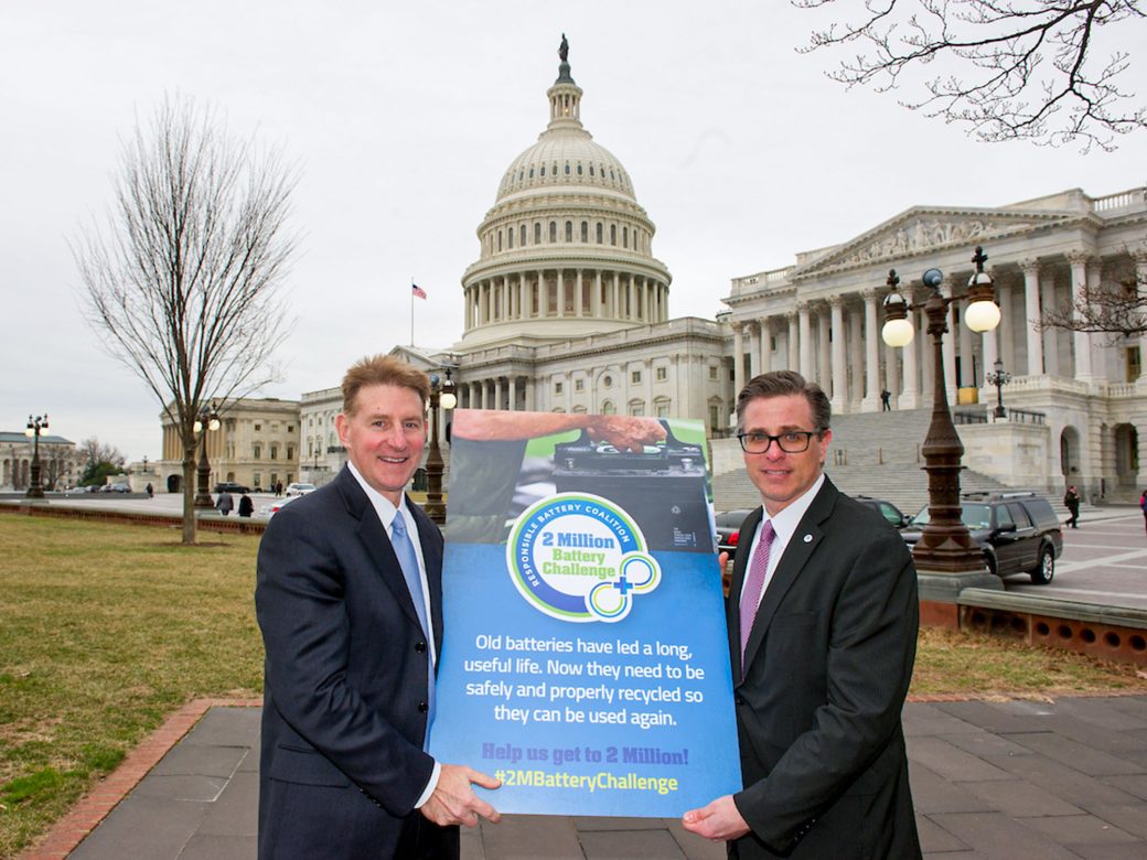Responsible Battery Coalition leaders—Pat Hayes and Adam Muellerweiss—standing in front of the United States Capitol in Washington, D.C. The are holding a large poster for the coalition.